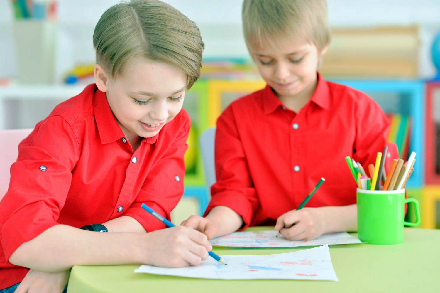 two-smiling-boys-red-shirts-drawing-with-pencils (1)